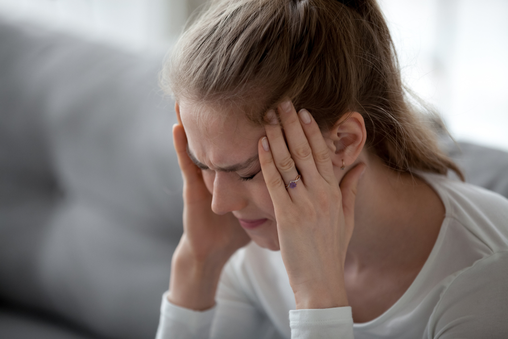 a woman with tiredness and a headache from iron deficiency