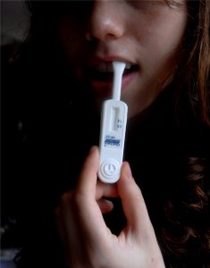 Mouth swab HIV self-test being used by a young woman